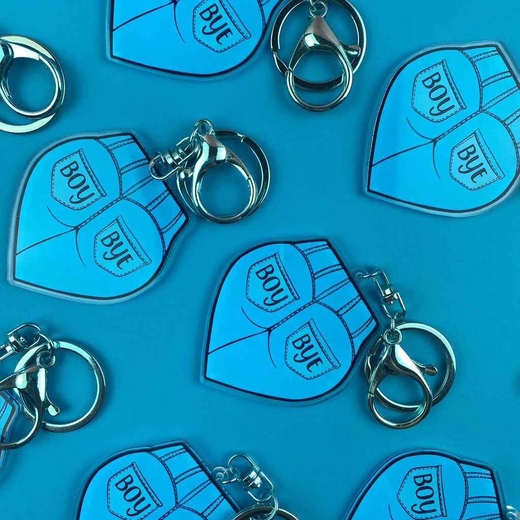 Blue keychains with 'BOY' and 'BYE' text on a blue background