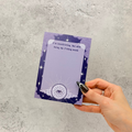 Hand holding a purple notepad with star design on a purple celestial background